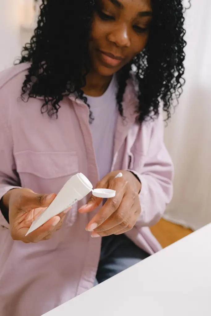 Femme appliquant une crème sur ses cheveux bouclés