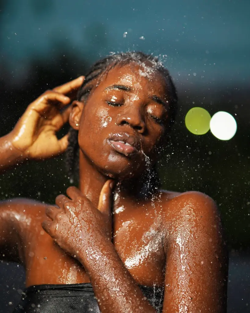 Portrait d'une femme recevant des gouttes d'eau sur le visage
